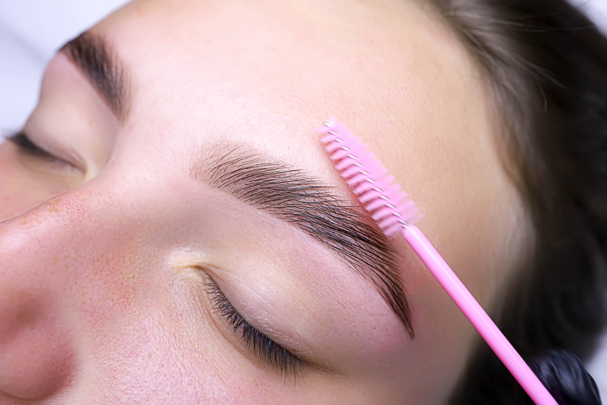 combing the hairs in the eyebrows with a brush after the pro